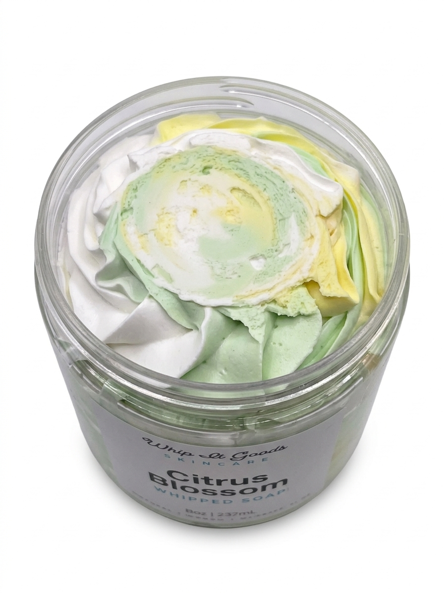 Jar of whipped soap with green, white, and yellow swirls on a white background